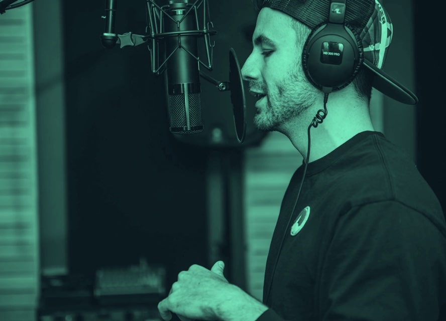 man in headphones speaking into a recording studio mic
